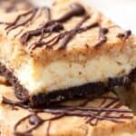 Titled image of two keto Samoa cheesecake bars piled on top of each other.