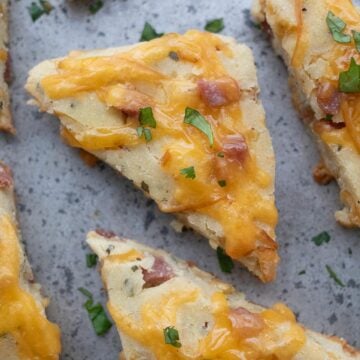 Top down image of ham and cheese scones on a metal baking sheet.
