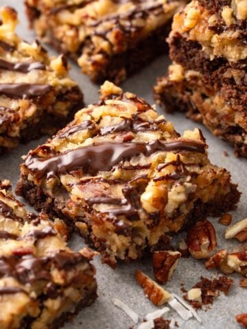 German chocolate brownies surrounded by chopped pecans and shredded coconut.