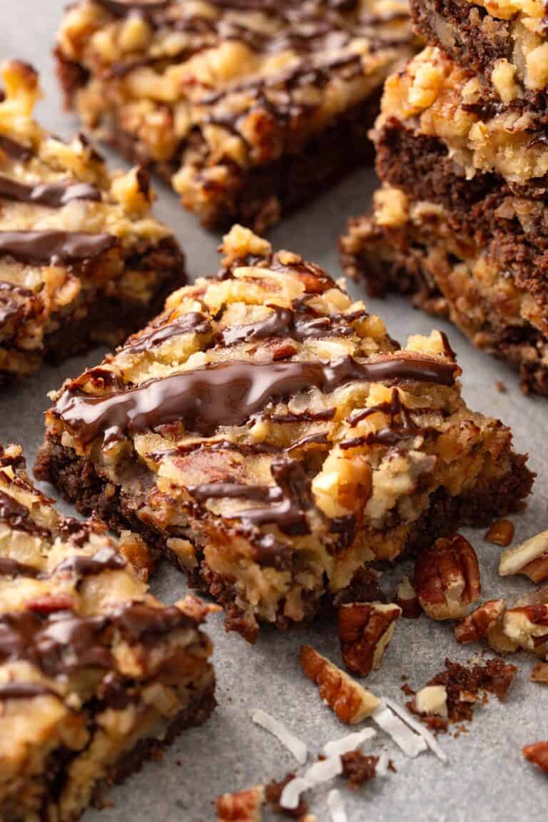 German chocolate brownies surrounded by chopped pecans and shredded coconut.