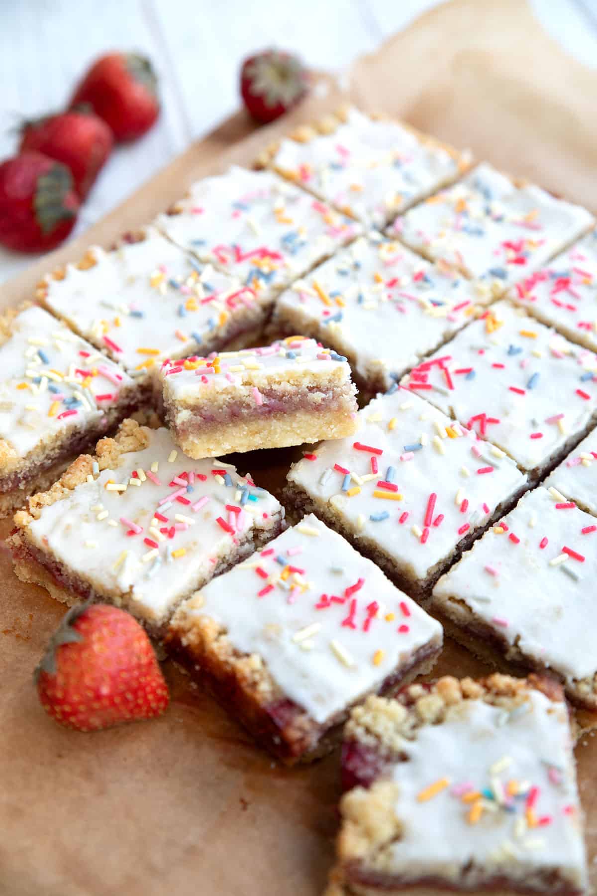 Low carb shortbread bars with jam filling cut up on a parchment lined cutting board.