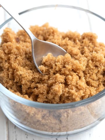 Close up shot of keto brown sugar alternative in a glass dish with a spoon in it.