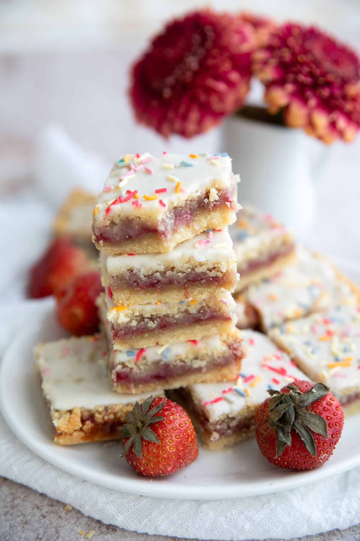 A stack of keto pop tart bars on a white plate, with a bite taken out of the top one.