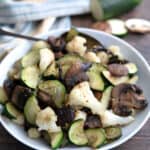 Sautéed Vegetables in a white dish on a brown wooden table.