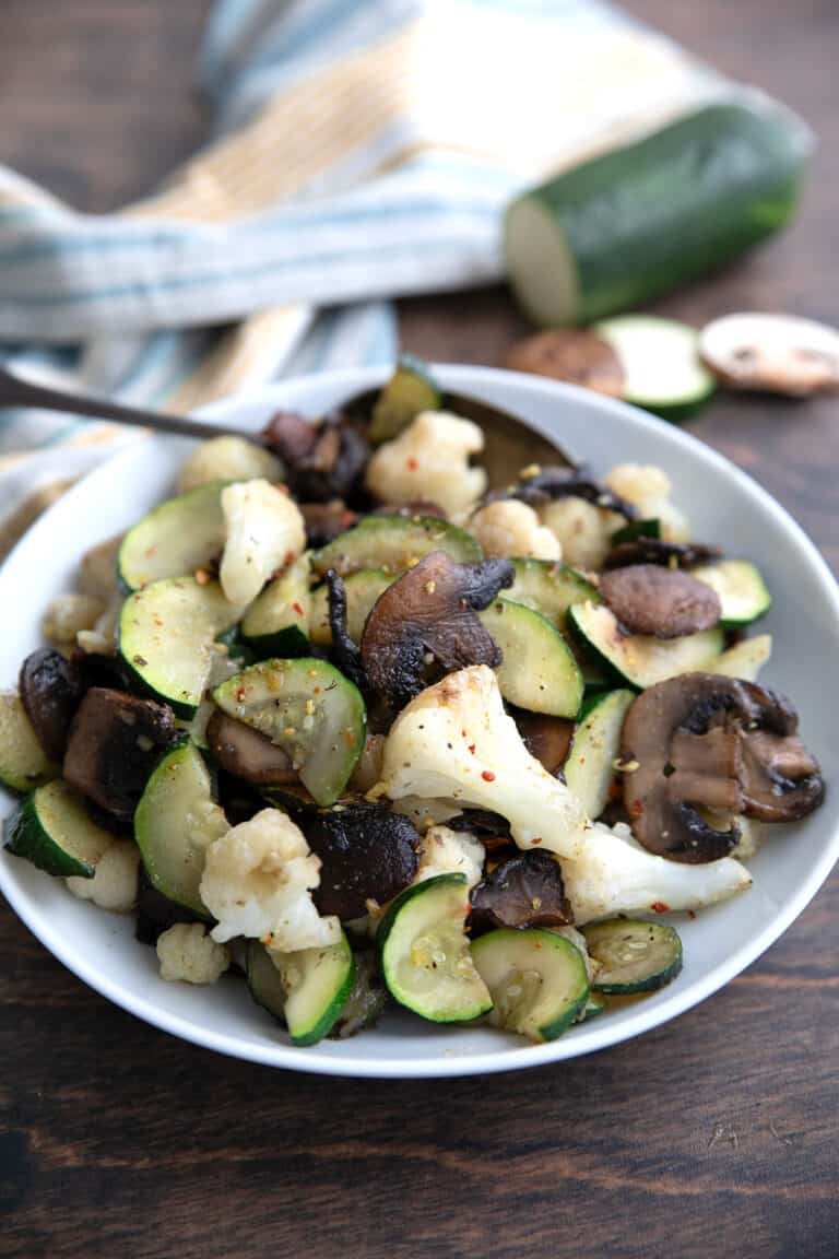 Sautéed Vegetables in a white dish on a brown wooden table.