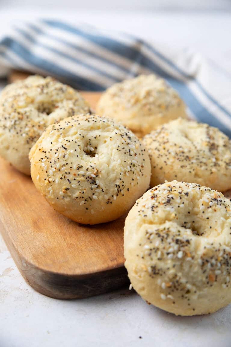 Cottage cheese protein bagels arranged on a wooden cutting board.