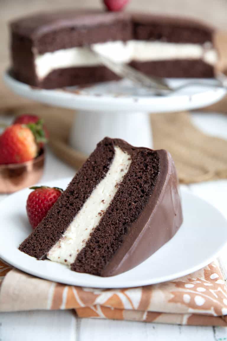 A slice of Keto Ding Dong Cake on a white plate in front of the rest of the cake.