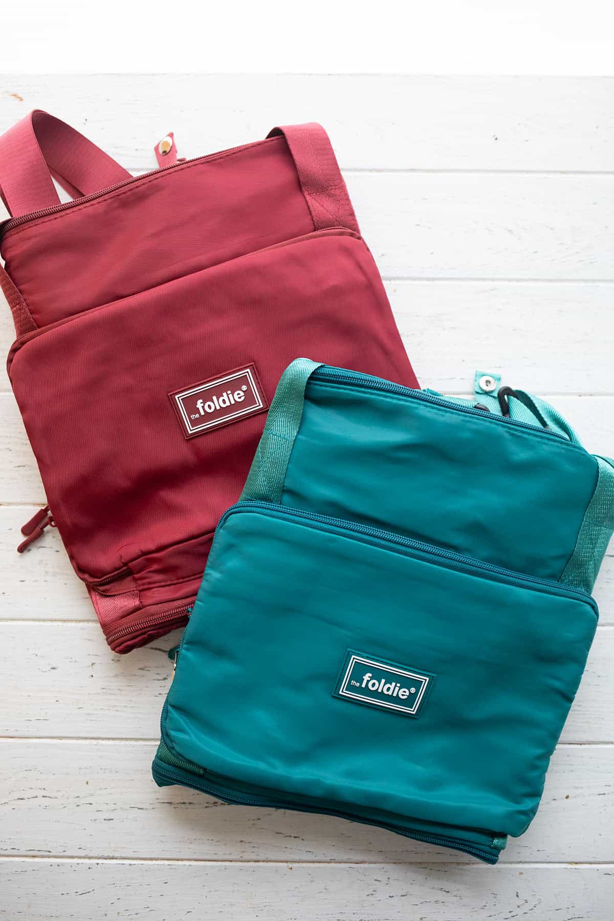 Top down image of two foldable Foldie tote bags, one in red and one in teal.