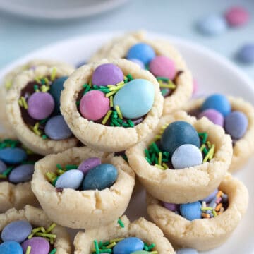 Close up shot of Easter Cookie Cup piled up on a white plate.