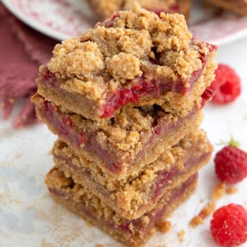 A stack of keto Peanut Butter and Jelly Bars with a bite taken out of the top one.