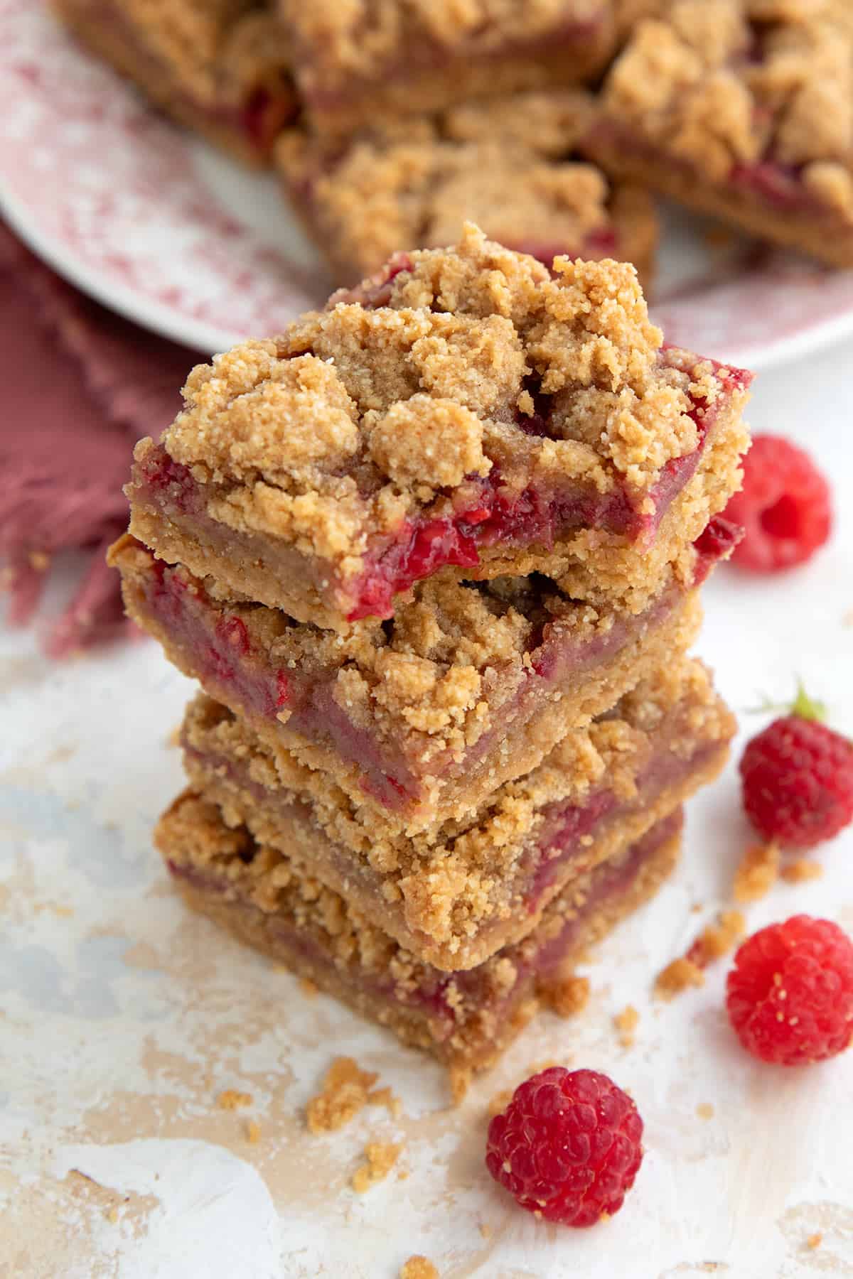A stack of keto Peanut Butter and Jelly Bars with a bite taken out of the top one.