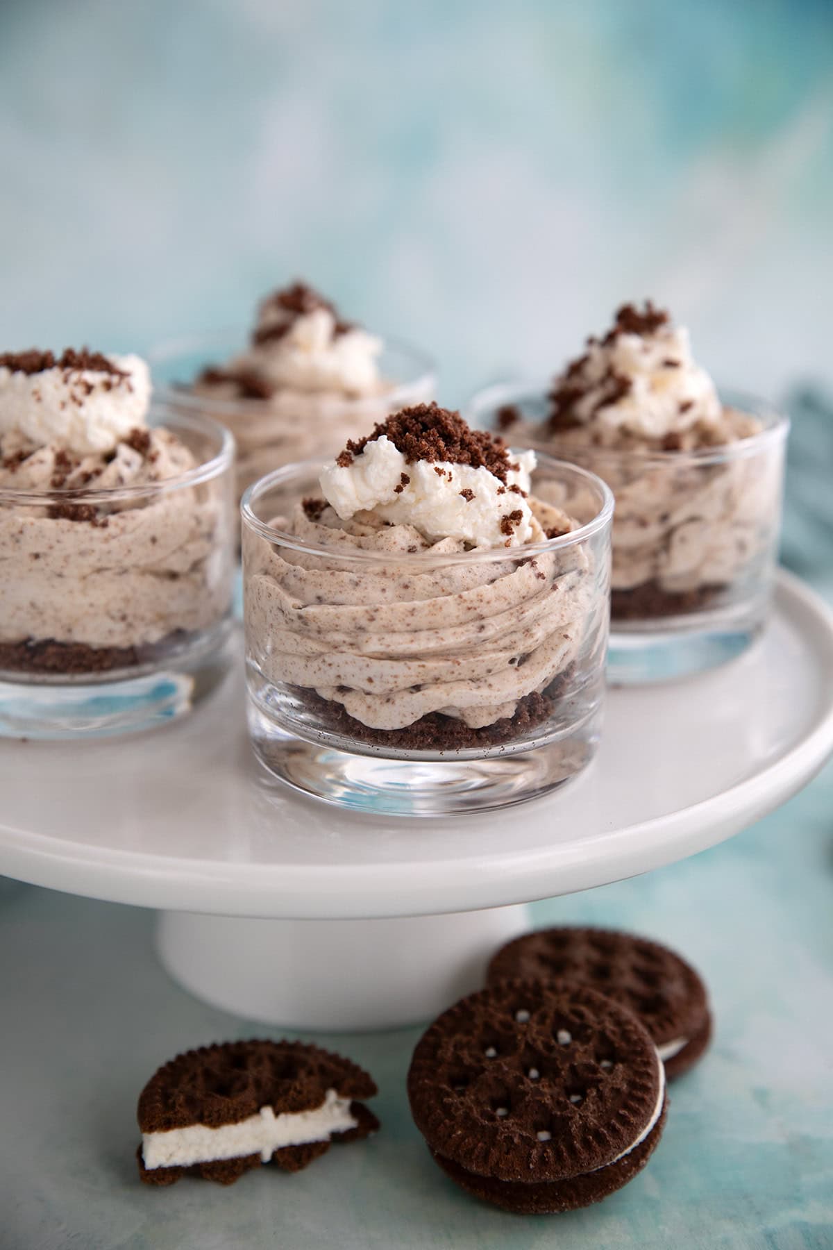 Four desserts cups filled with Keto Cookies and Cream Mousse on a white cake stand.