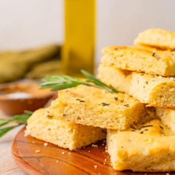 A plate of Keto Focaccia Bread sits in front of a bottle of olive oil.