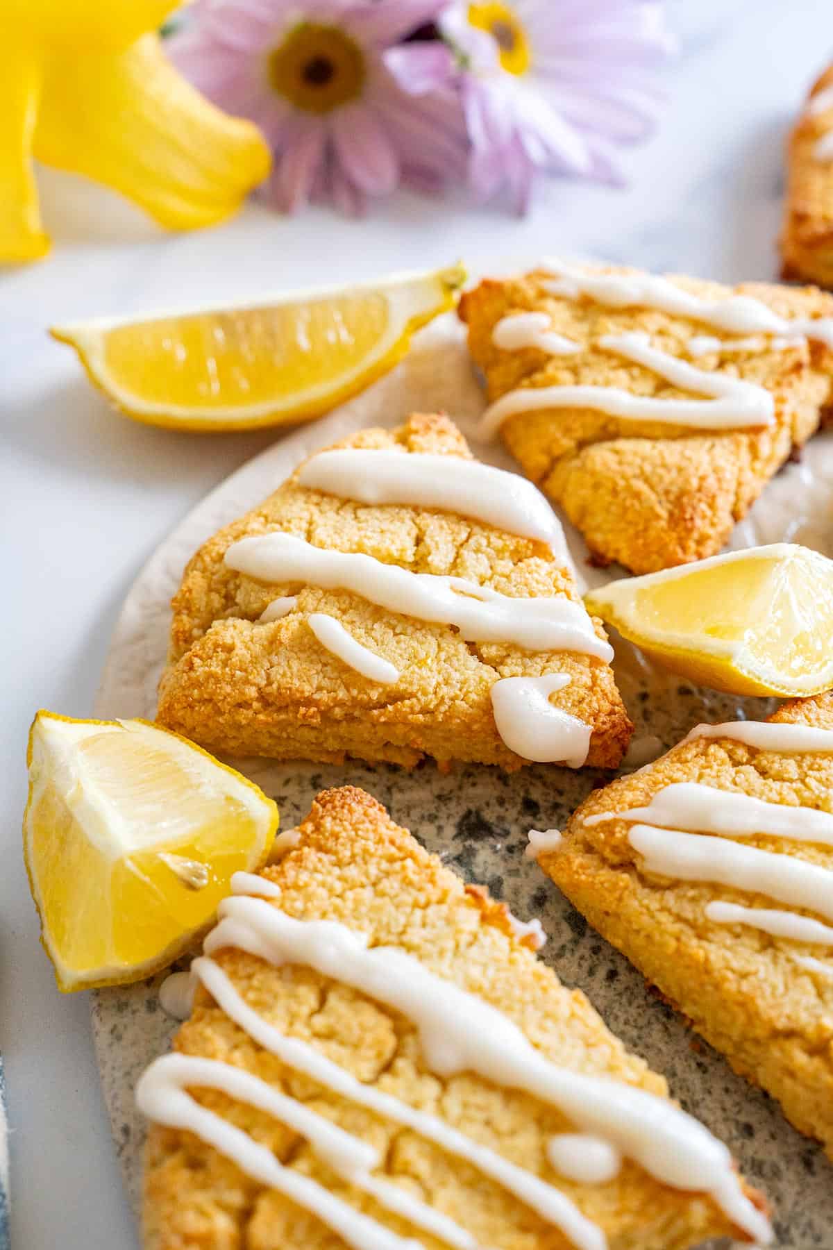 A plate with Keto Lemon Ricotta Scones and lemon wedges.