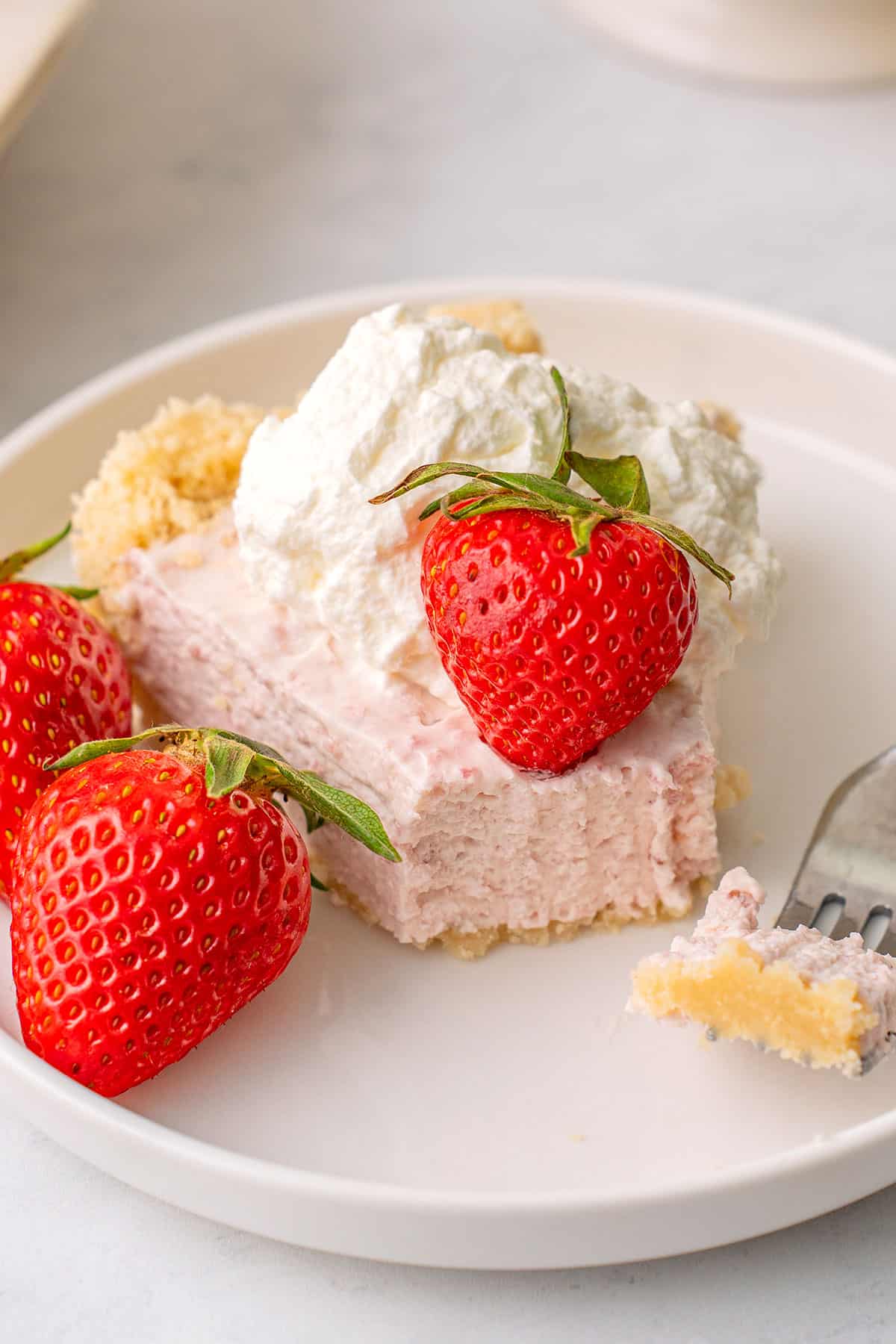 Close up shot of a slice of Keto Strawberry Cream Pie with a forkful taken out of it.