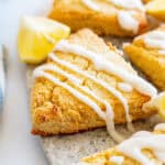 Close up shot of keto lemon scones on a plate with lemon wedges.