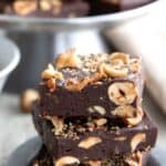 Titled image of a stack of Keto Chocolate Hazelnut Fudge on a small pewter plate.