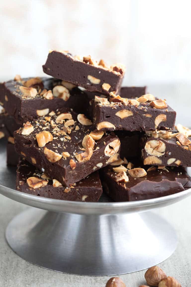 Sugar Free Hazelnut Fudge piled up on a metal cake stand.