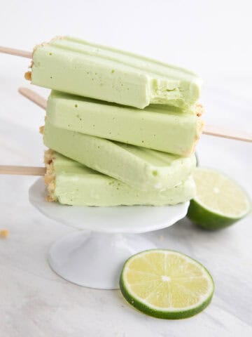 A stack of Key Lime Protein Popsicles on a white cupcake stand.