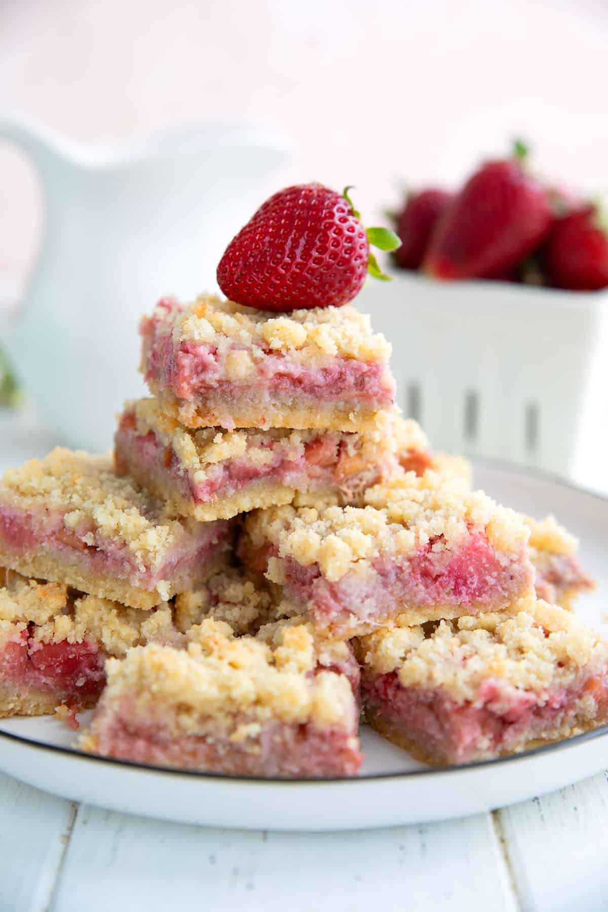 Keto strawberry rhubarb crumb bars on a white plate on a white table.