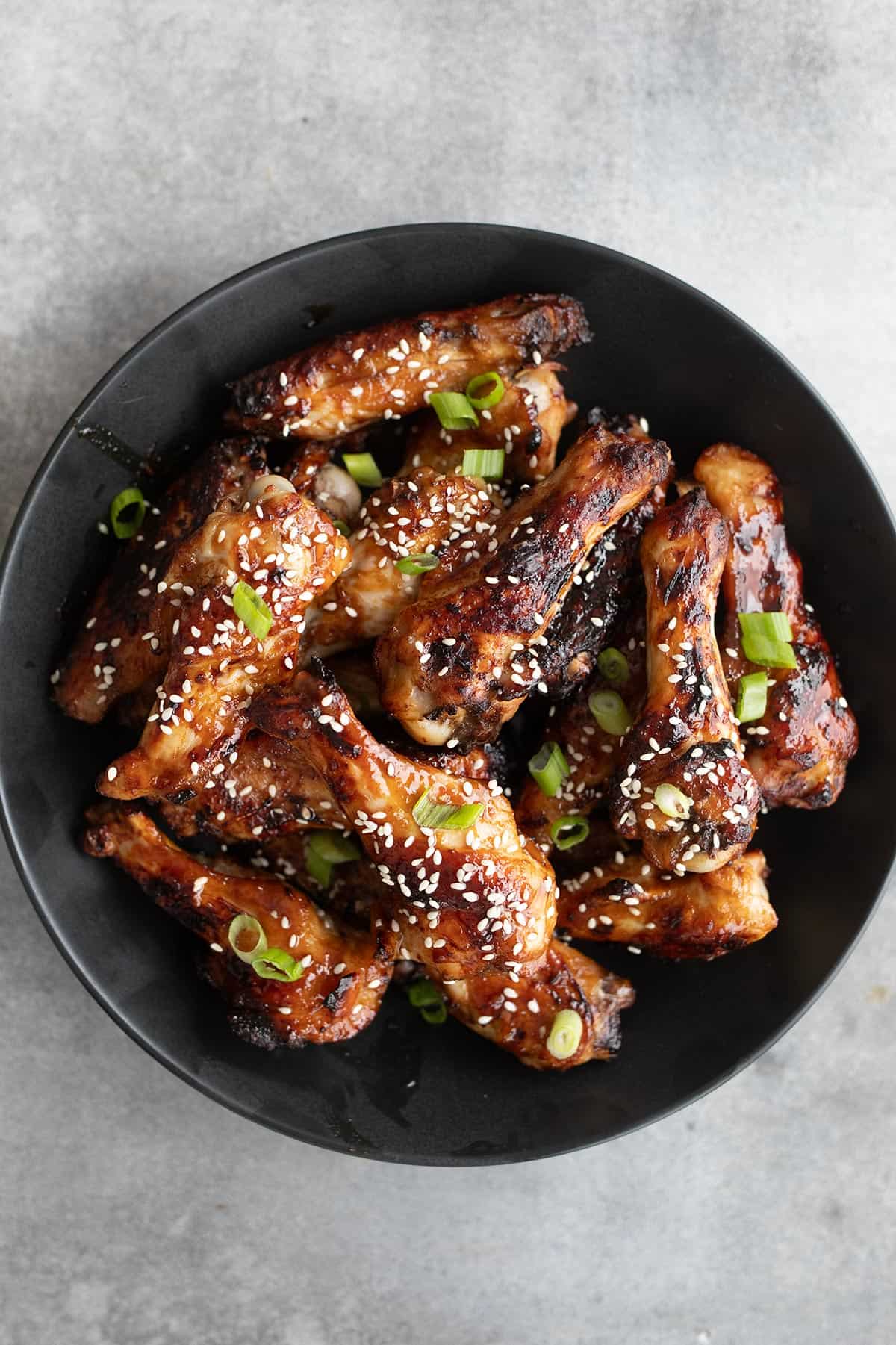 Top down image of a black bowl filled with Keto Teriyaki Chicken Wings.