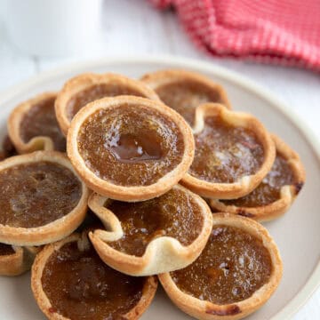 Keto Butter Tarts on a plate over a white wooden table.