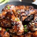 Titled image of a stack of Keto Teriyaki Wings piled up in a black bowl.