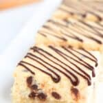 Titled image of Keto Cannoli Cheesecake Bars on a white rectangular tray.