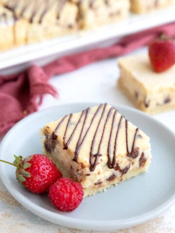 A keto protein cheesecake bar on a small gray plate with berries.