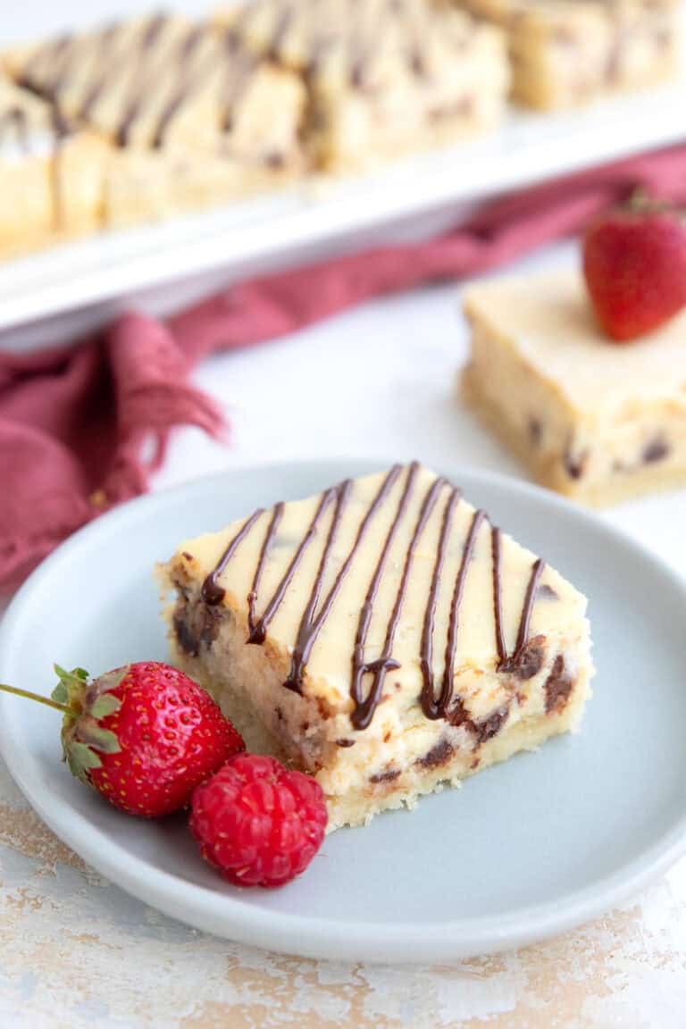 A keto protein cheesecake bar on a small gray plate with berries.