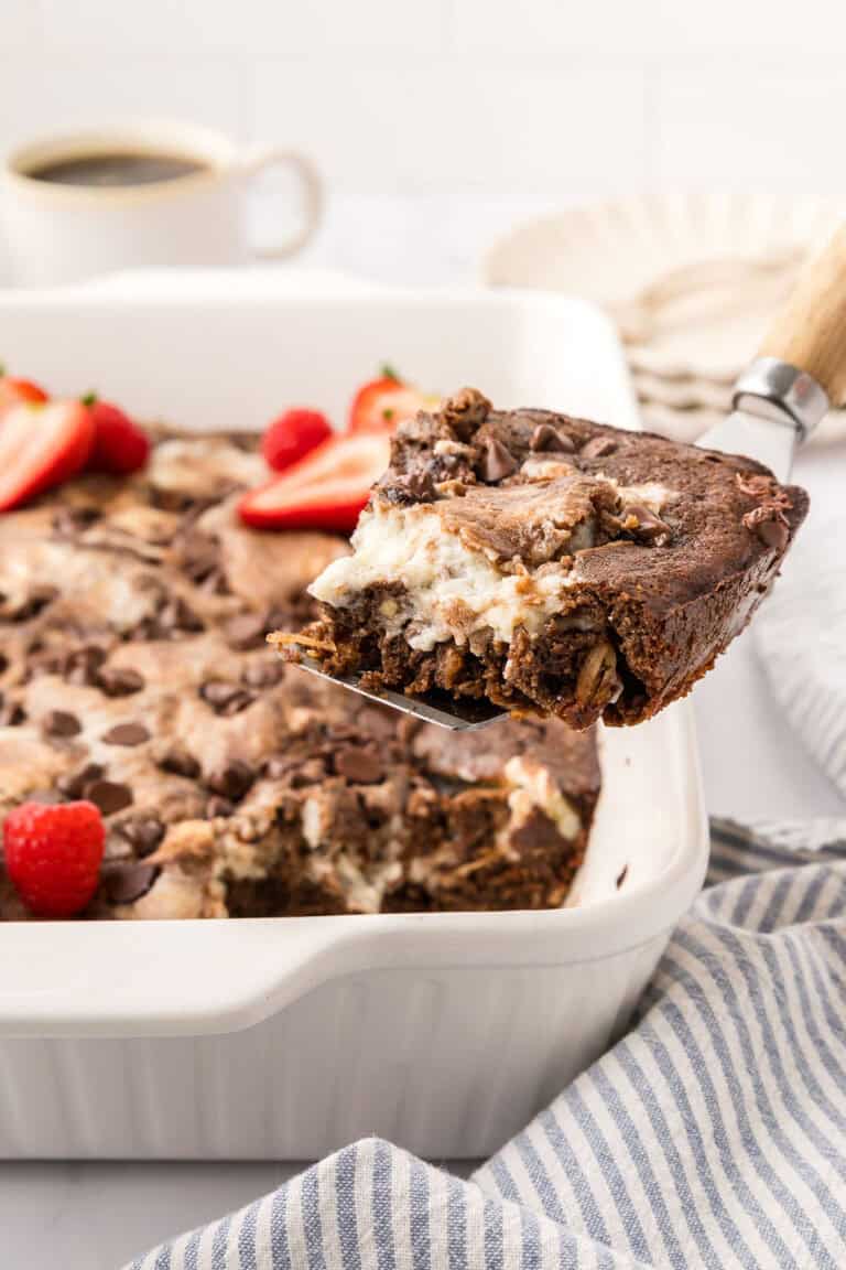 A slice of Keto Earthquake Cake being lifted away from the rest of the cake on a spatula.