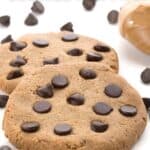 Titled Pinterest image of two large low carb peanut butter cookies surrounded by chocolate chips.