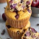 Close up of a stack of Keto Cherry Chocolate Chip Muffins on a concrete table.