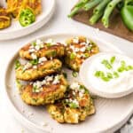 Keto Zucchini Fritters on a white plate with a bowl of yogurt for dipping.