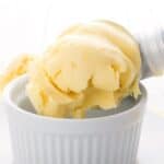 Titled Pinterest image of keto lemon ice cream being scooped into a white ramekin.