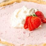 Keto Strawberry Cream Pie in a pie plate with whipped cream and strawberries on top.