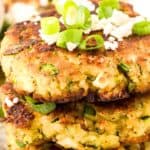 Titled image of a stack of Keto Zucchini Fritters with green onion and feta on top.