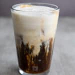 A glass of Iced Protein Coffee in a gray concrete table.