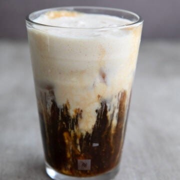 A glass of Iced Protein Coffee in a gray concrete table.