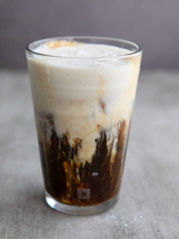 A glass of Iced Protein Coffee in a gray concrete table.