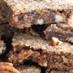 Titles image of a close up shot of Keto Pecan Chewy Bars piled upon on a plate.