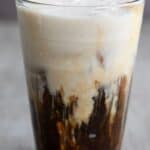 Titled image of a glass of Keto Iced Protein Coffee on a gray table.