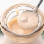 Titled image close up shot of Chipotle Ranch Dressing being spooned out of a jar.