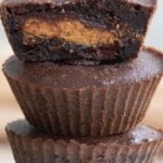 Titled image of Keto Air Fryer Brownies on a white cupcake stand with the top one cut open to show the peanut butter cup inside.