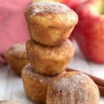 Titled Pinterest image of a stack of keto apple cider donut bites on a white wooden table.