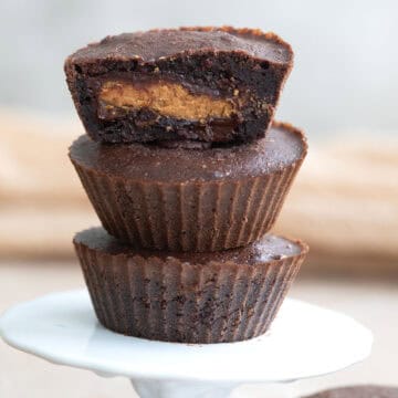 Three keto peanut butter stuffed brownies on a white cupcake stand.