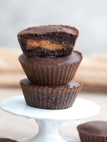 Three keto peanut butter stuffed brownies on a white cupcake stand.