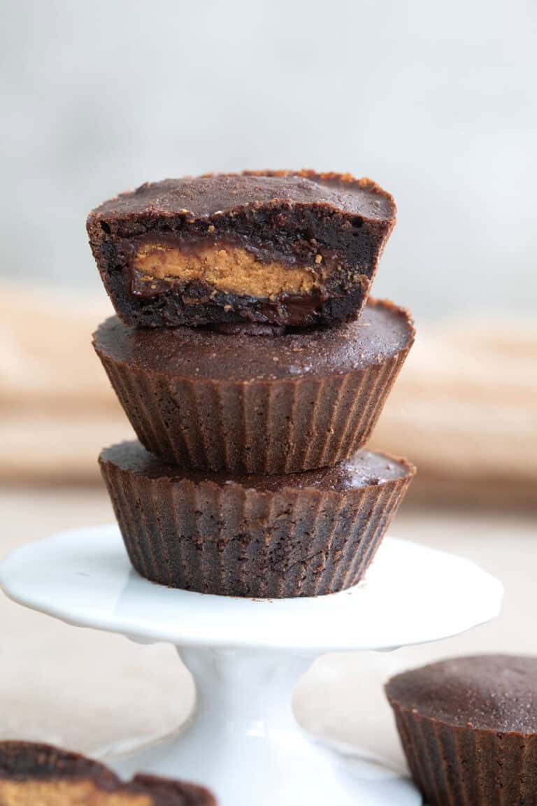 Three keto peanut butter stuffed brownies on a white cupcake stand.