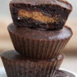 Close up shot of a stack of keto peanut butter cup brownies with the top one cut open.