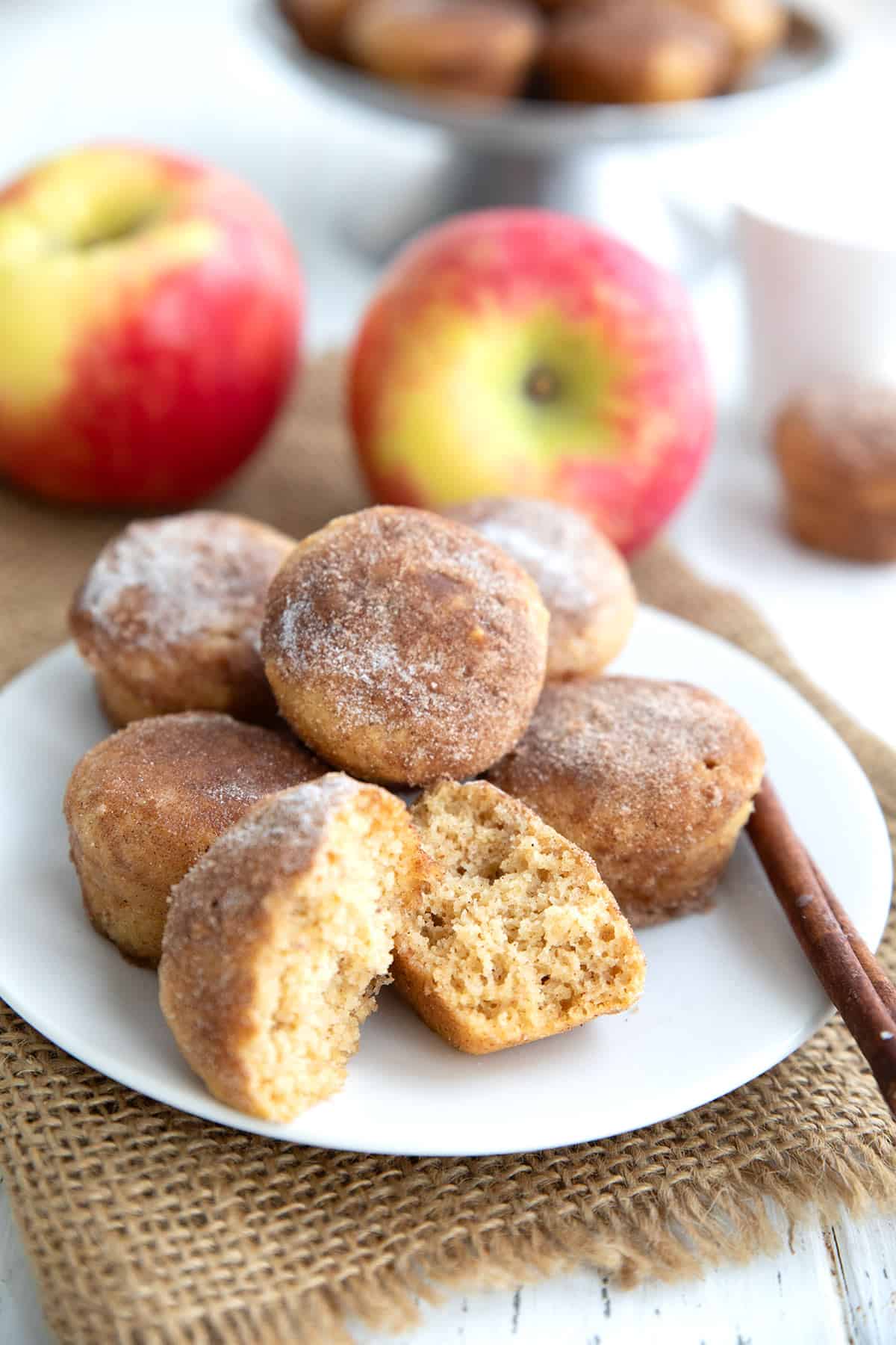 Keto Apple Cider Donut Bites on a white plate with one broken open to show the inside.